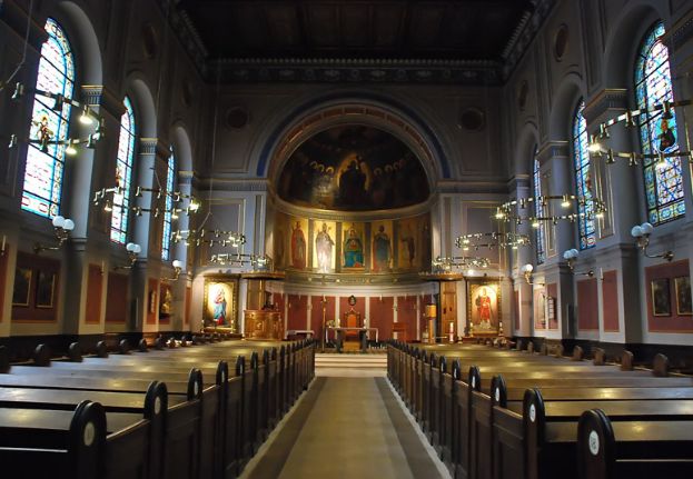 Interior of St. Ansgar’s Church in Copenhagen with wooden pews, stained glass windows, chandeliers, and altar