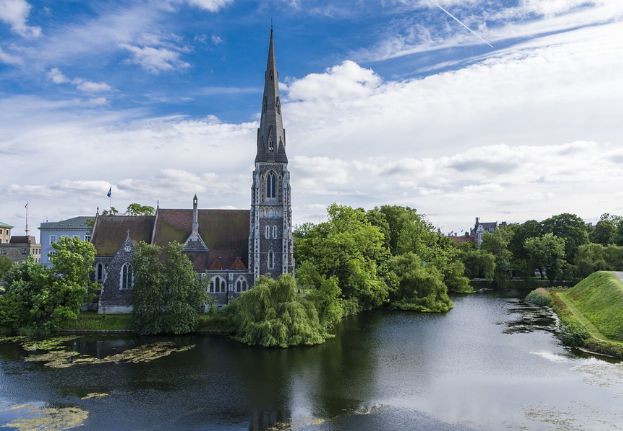 St. Alban's church surrounded by trees and water in Copenhagen