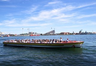 Kanlbåd med gæster sejler gennem Københavns havn i Danmark