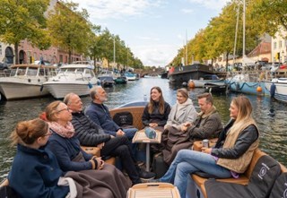 Group of guests enjoying a cozy Hygge boat tour through Christianshavn Canal in Copenhagen