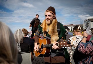 Operasanger udklædt som viking spiller guitar for gæster ombord på en kanalbåd i København
