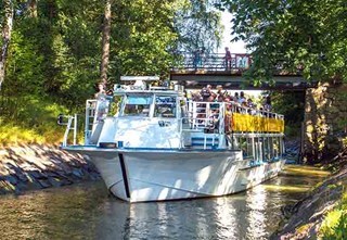 Sightseeing boat cruising through the narrow Degerö Canal in the archipelago of Helsinki