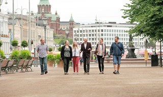 Ryhmä kävelemässä Esplanadin puistossa Helsingissä oppaan johdolla yksityisellä kävelykierroksella.