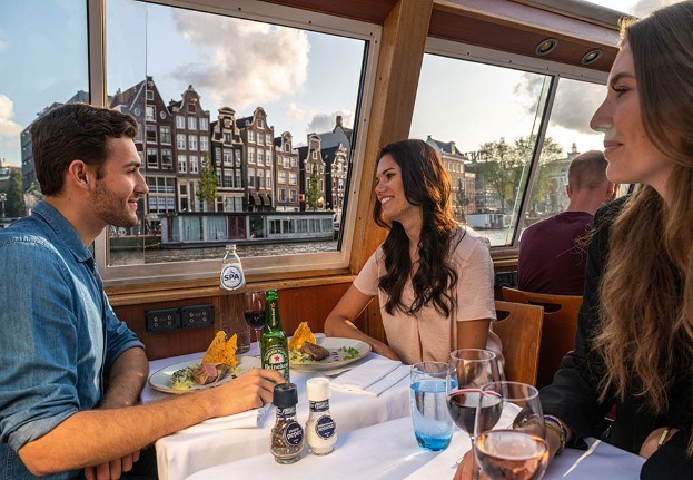 Een stel geniet van een diner cruise met een prachtige zonsondergang