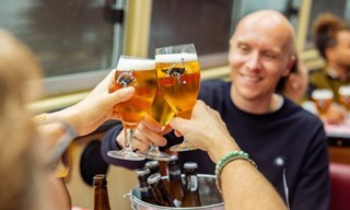 Friends clink glasses of Dutch craft beer during a beer cruise tasting experience.