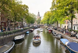 Open boot en een waterfiets erachter met het Rijksmuseum op de achtergrond