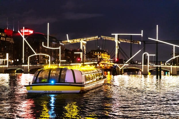 Rondvaartboot van Stromma tijden Amsterdam Light Festival bij de Magere brug