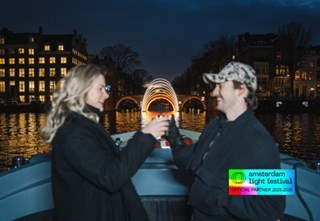 Een stel dat een teder moment deelt bij een lichtkunstinstallatie