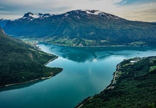 Aerial view of turquoise Lake Oldevatnet in Olden, surrounded by green valleys and mountains