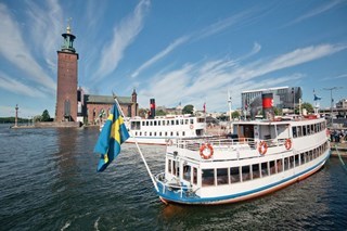 Strommas passagerarbåt vid avgångsplatsen Klara Mälarstrand i Stockholm med Stadshuset i bakgrunden.