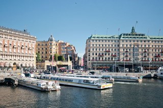 Strommas sightseeingbåtar vid avgångsplatsen Strömkajen i Stockholm med Grand Hotel i bakgrunden.