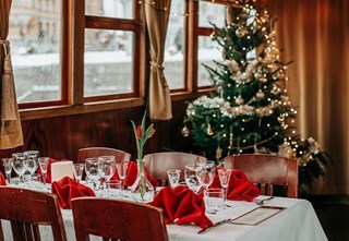 A set dining room with a Christmas tree in the background