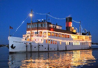 S/S Stockholm lysande av juldekorationer under julbordskryssning i Stockholms skärgård en vinterkväll.