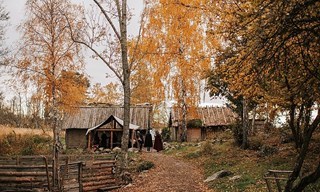 Reconstructed Viking houses among autumn trees in Birka the Viking City on Björkö.