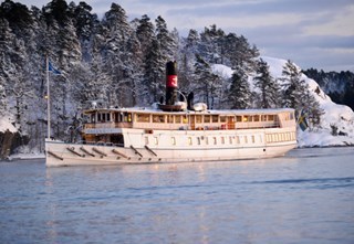 The archipelago boat M/S Östanå I cruises through a wintry archipelago landscape.