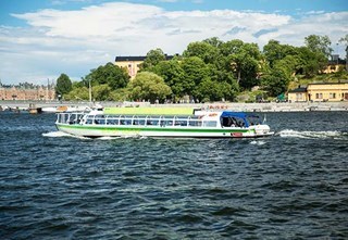 Green Hop On-Hop Off boat next to Skeppsholmen