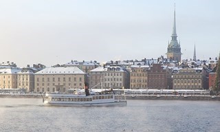 M/S Angantyr kryssar genom Stockholms vintriga hamn, med snötäckta Gamla stan i bakgrunden.