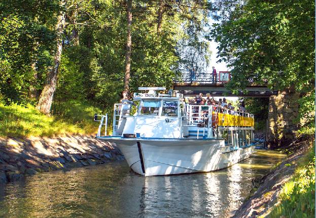 Beautiful Canal Cruise sightseeing boat gliding through the narrow Degerö Canal