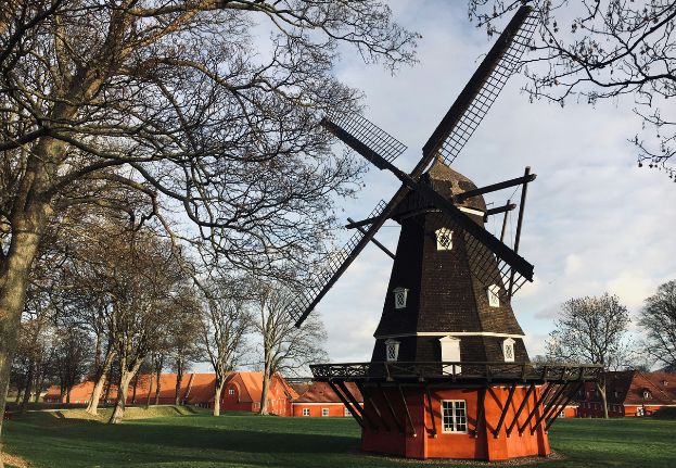 Historic brown and red windmill in front of the Citadel in Copenhagen.