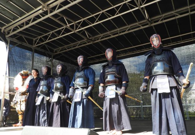 Martial artists in traditional Japanese kendo armor with bamboo swords doing a stage demo. ©Kazuhiko Takegawa