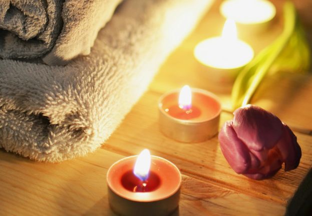 Candles and a flower creating a tranquill atmosphere in a spa area.