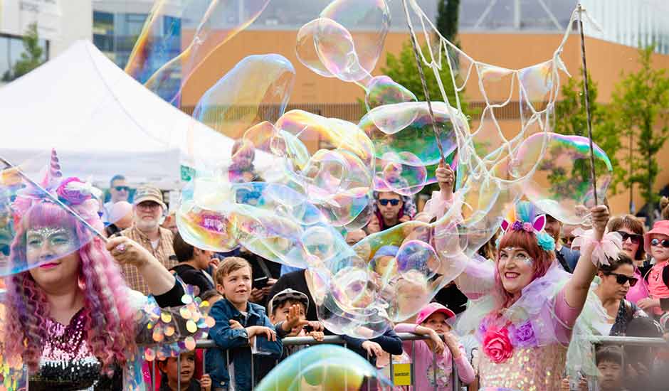 Large audience watching huge soap bubbles in an event in the Töölönlahti Park, Helsinki