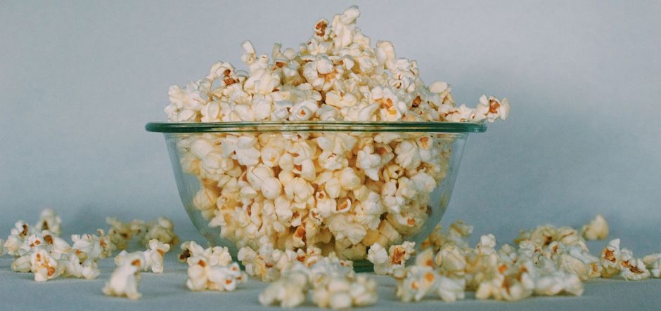 A glass bowl overfilled with popcorn